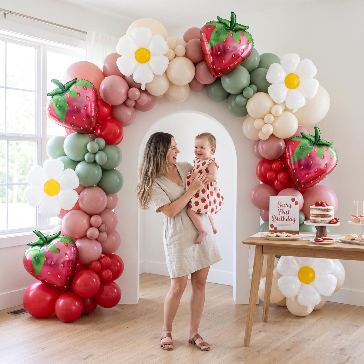 Berry First Birthday balloon garland styled at a party
