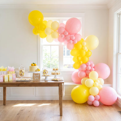 A Little Lemon balloon garland installed on a wall at home