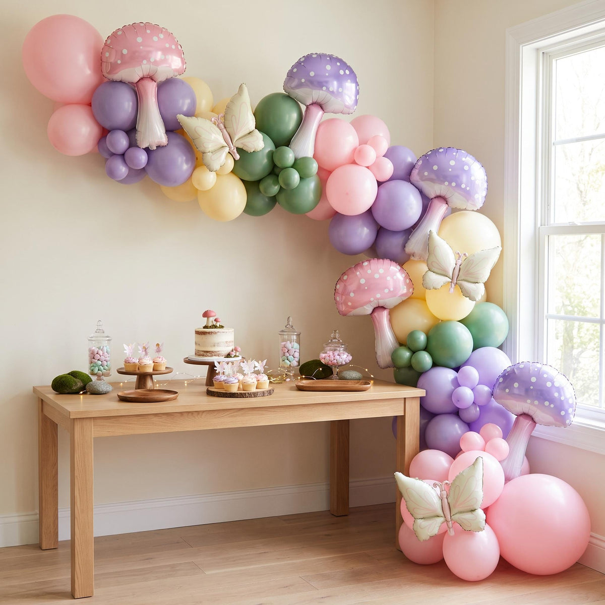Fairy First Birthday balloon garland installed on a wall at home